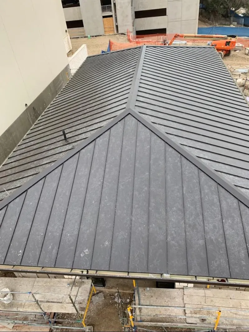 Commercial metal roof construction with crane equipment in Belpre